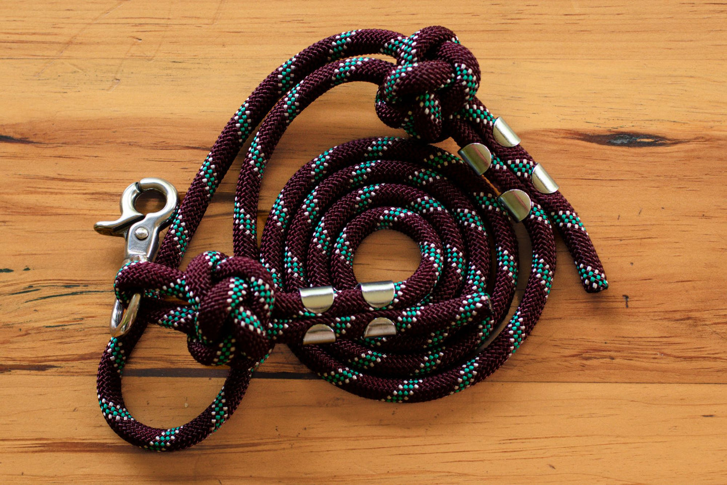 Rope dog leash with metal clips on a wooden surface