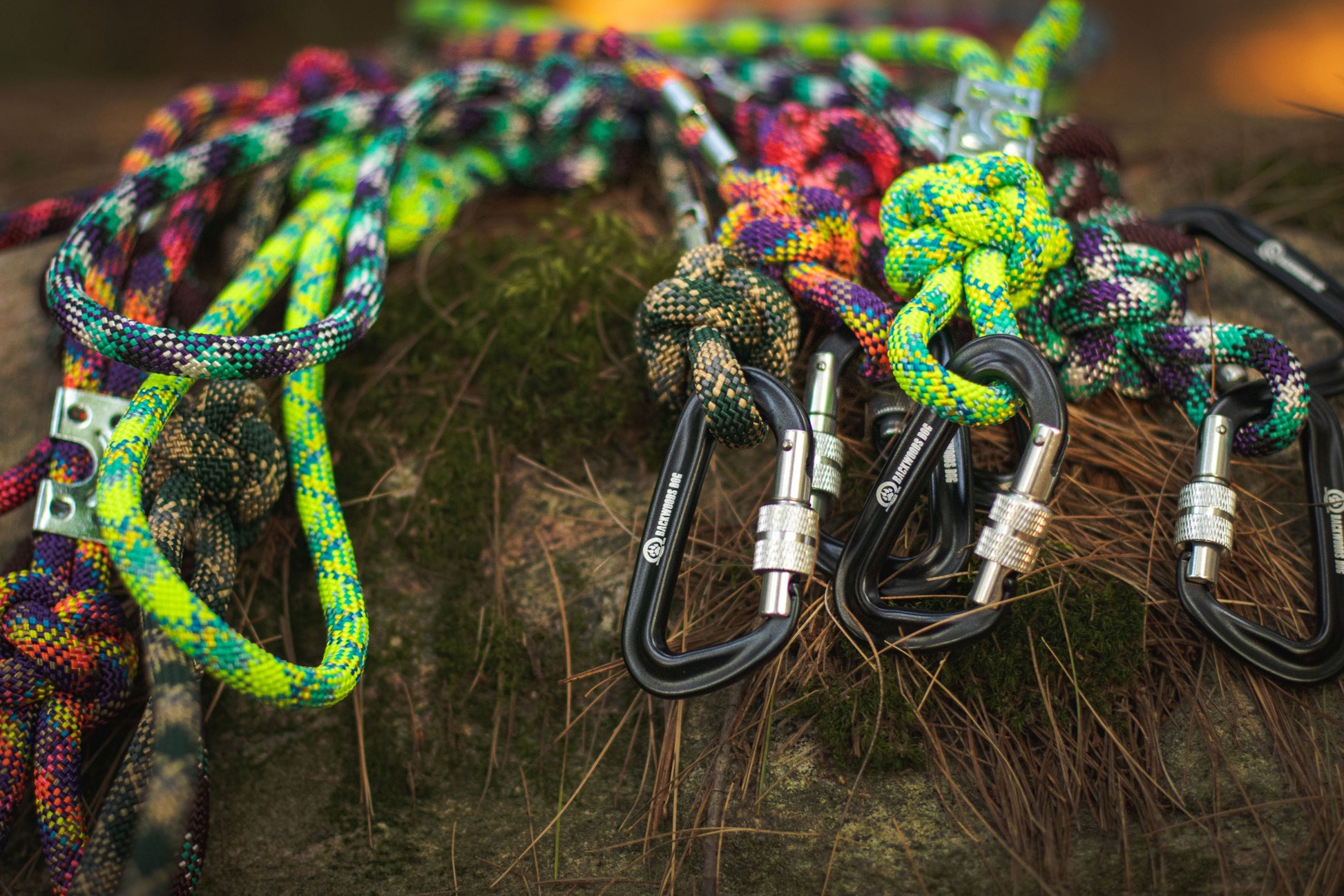 Colorful climbing ropes with carabiners on a wooden surface