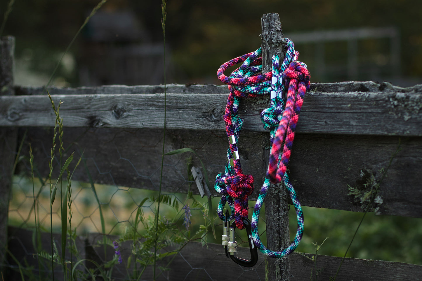 Multicolored braided rope tied to a wooden post with a natural background