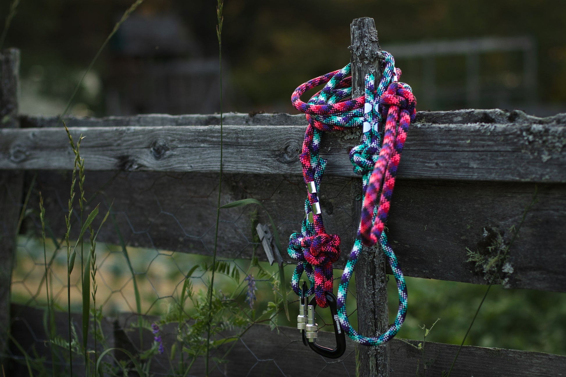Multicolored braided rope tied to a wooden post with a natural background