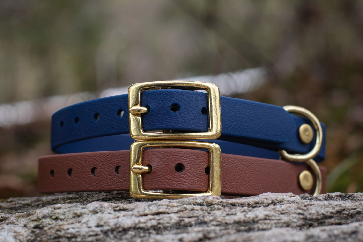 Backwoods Dog 5/8" BioThane Brass buckle collar stacked on a rock in navy and brown